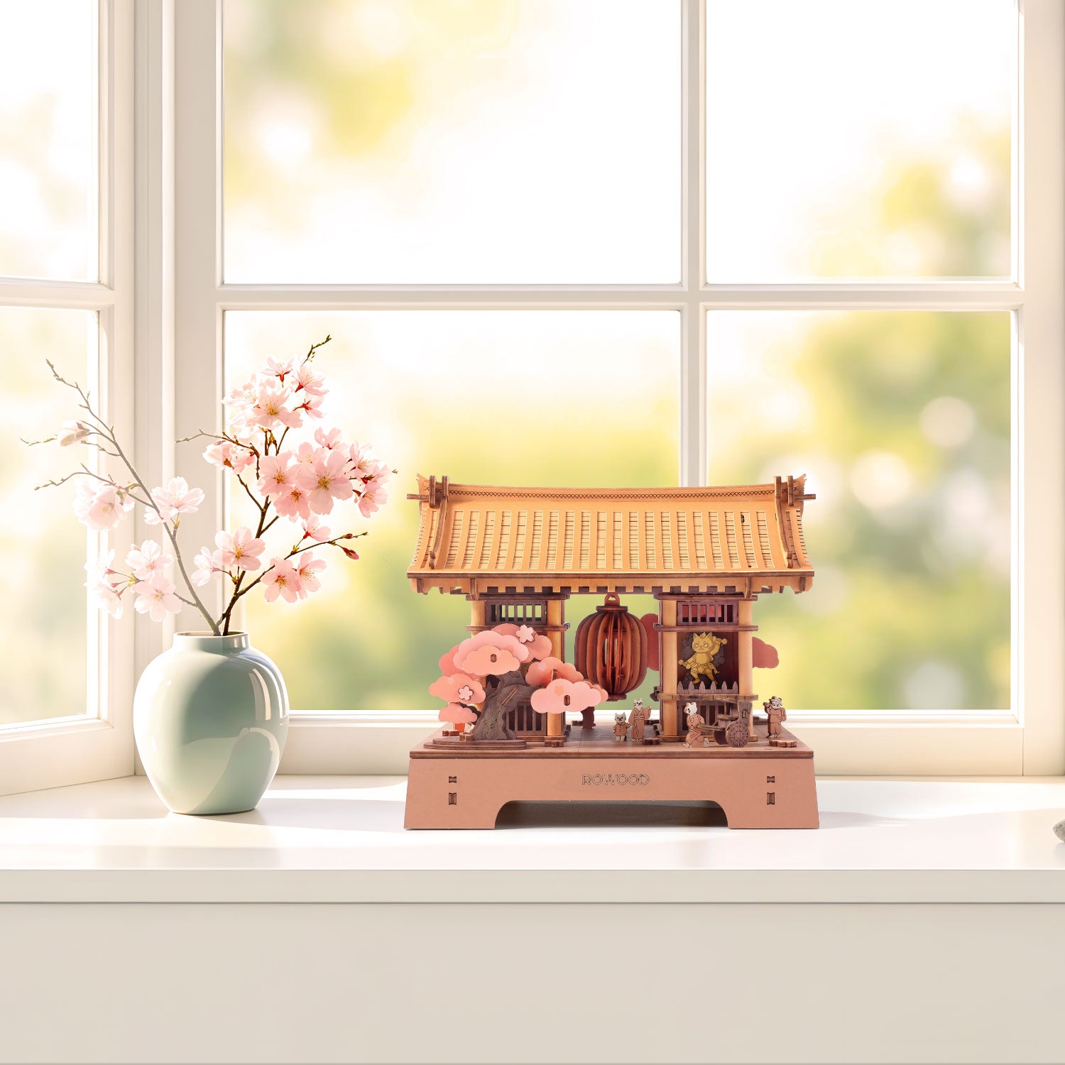 Sacred Sakura Temple TGA08 displayed beside a vase of cherry blossoms on a sunlit windowsill