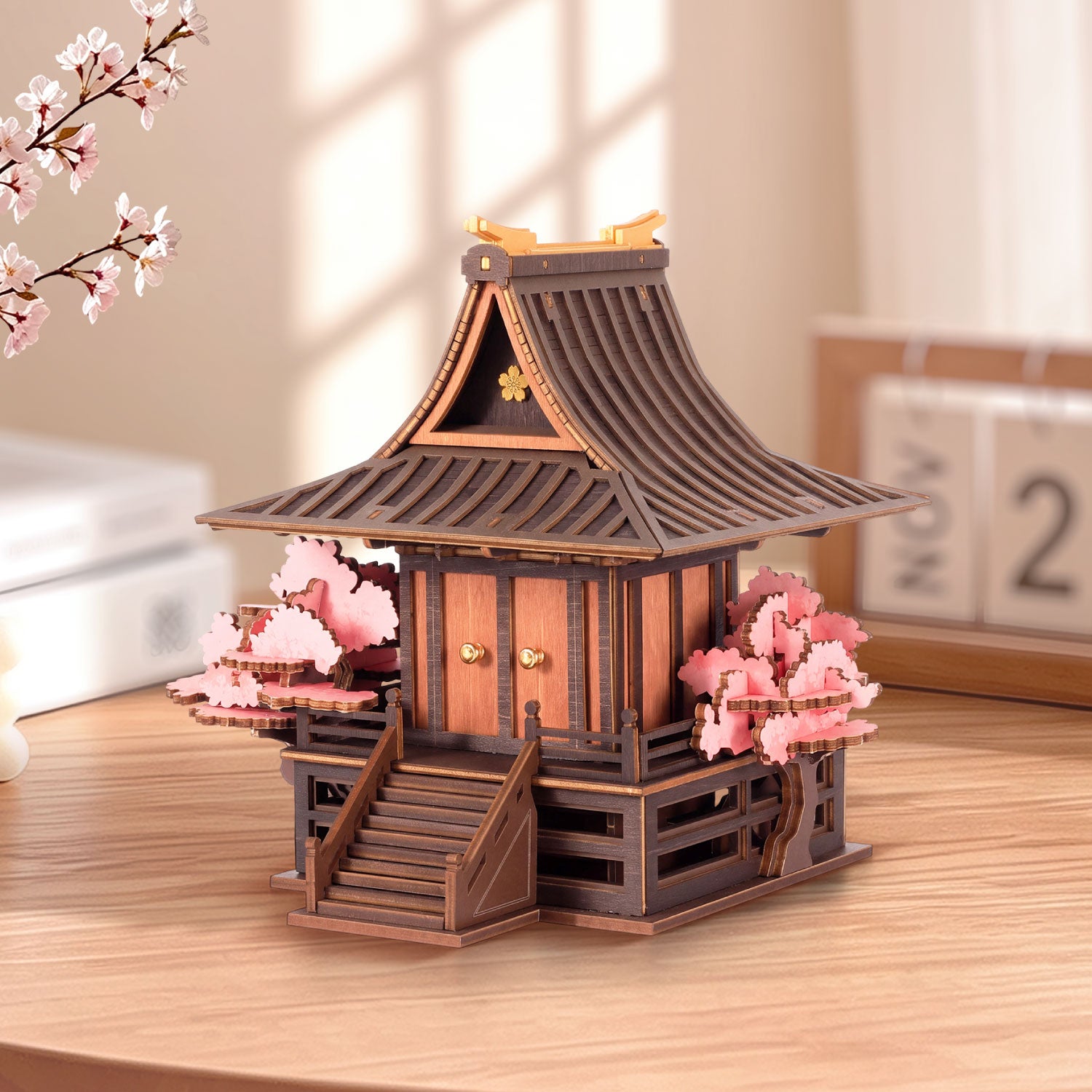 Angled view of Sakura Retreat TGA09 showing the curved roof, raised platform, and pink blossoms