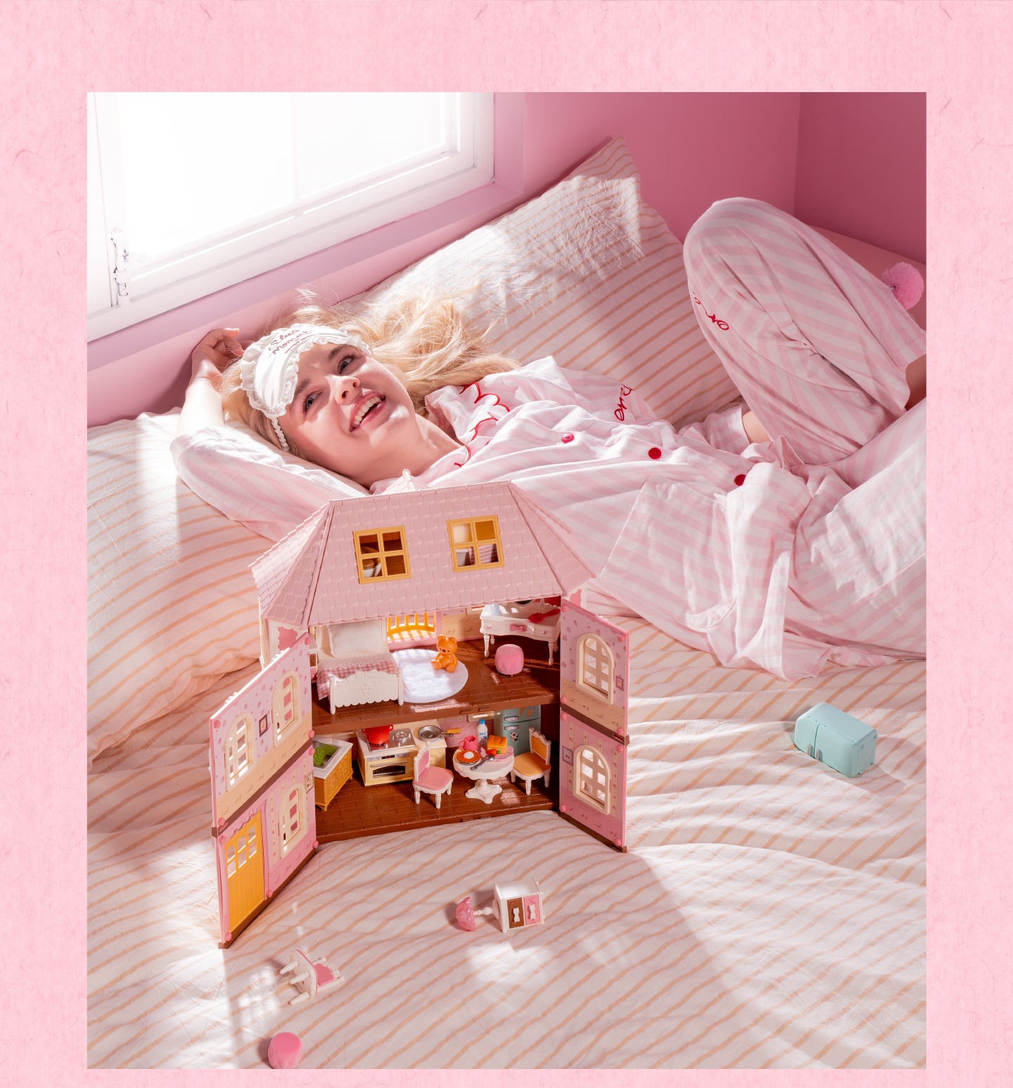 Fairy Rose Cottage open dollhouse with lighted rooms on bed