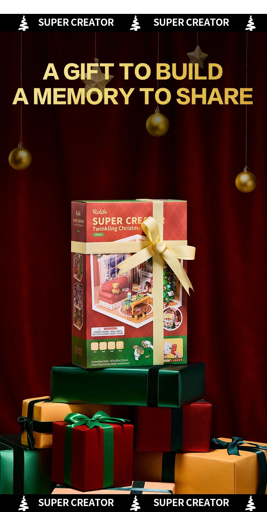 Rolife Super Creator Twinkling Christmas box tied with gold ribbon on stacked gift boxes against red curtain, with hanging gold baubles.