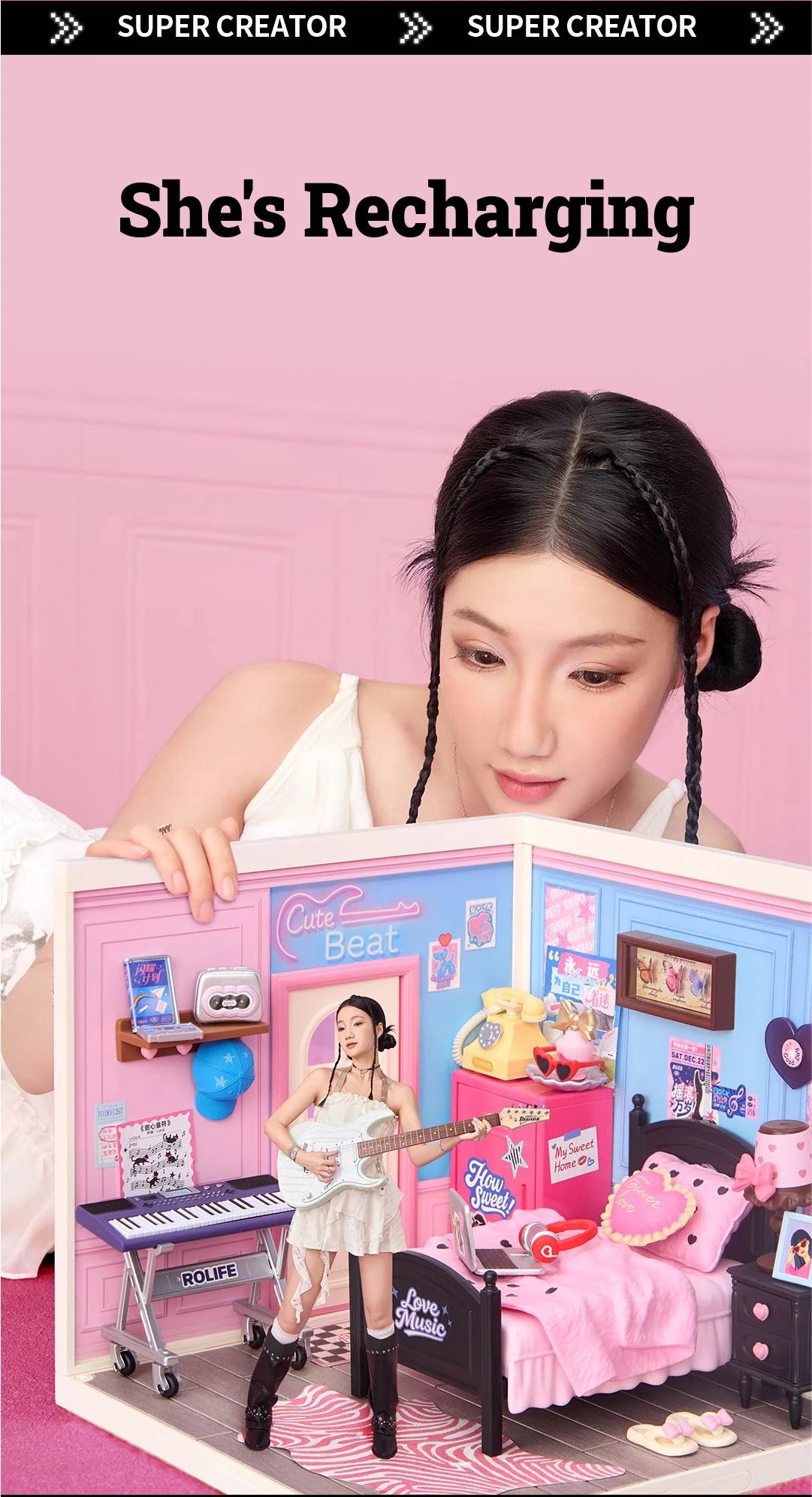 Person leaning over a Rolife miniature bedroom, with a cutout figure holding a guitar standing inside the room near the keyboard and bed.