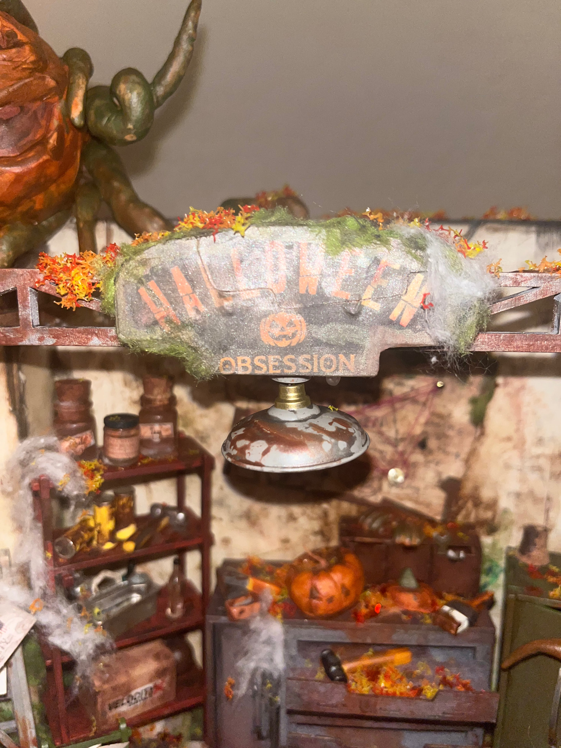 Halloween Obsession sign, distressed lamp, and workbench details in the customized DG165 workshop