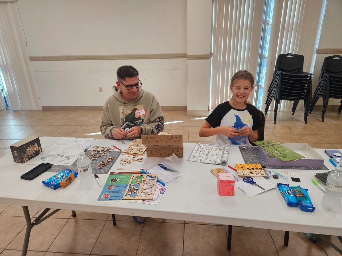 A family working together on a miniature project at the Copperas Cove meetup