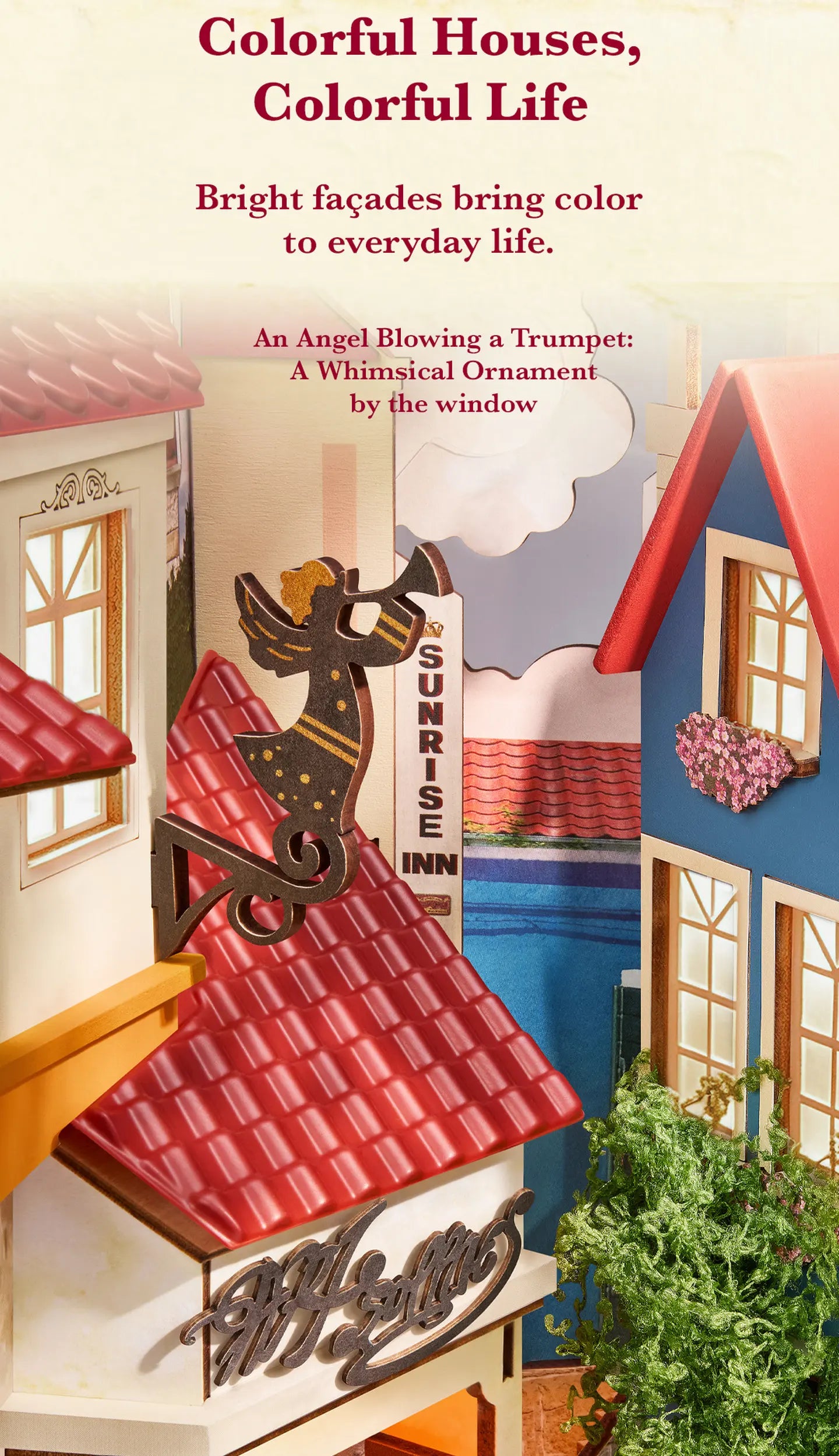 Miniature colorful house facades with red tiled roofs, blue and cream walls, flower boxes, a trumpet-blowing angel ornament, and a Sunrise Inn sign.