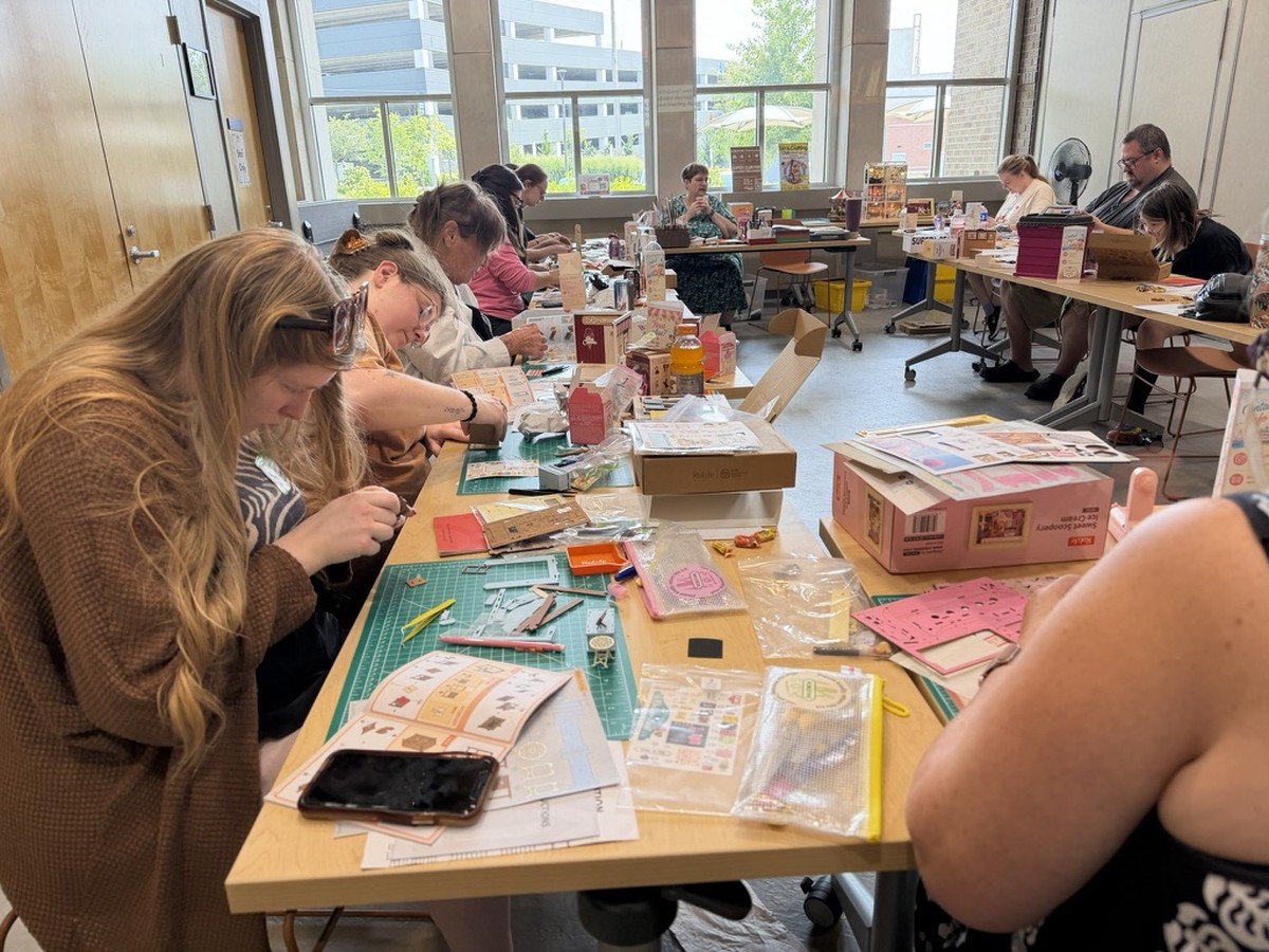Makers building ice cream-themed miniature kits around tables in Fishers