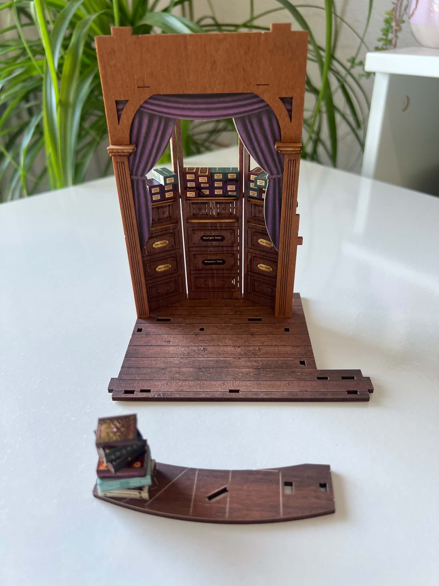 Teilweise zusammengebauter Whisper Magic Shop mit separaten Miniaturbüchern und Komponenten auf einem Tisch