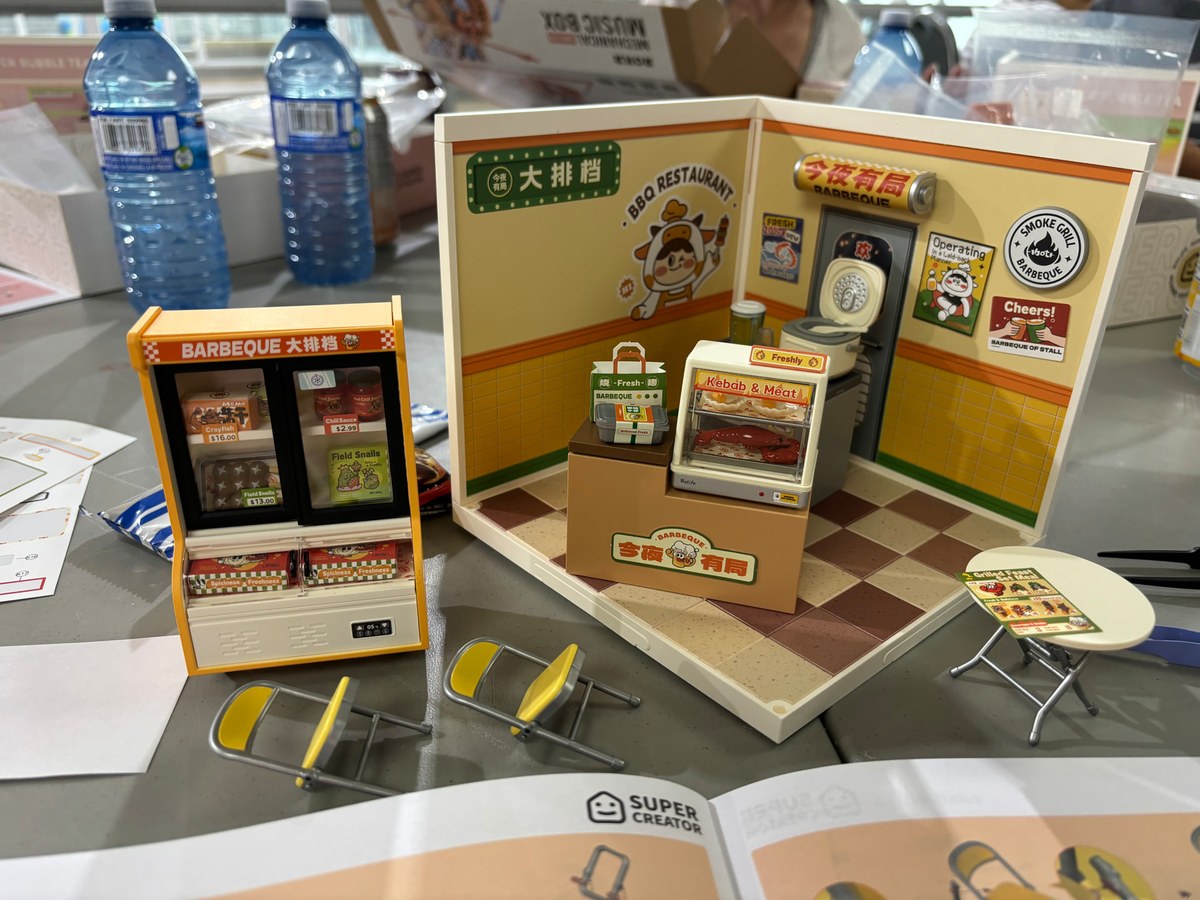 A completed miniature shop scene on a table at the Markham workshop
