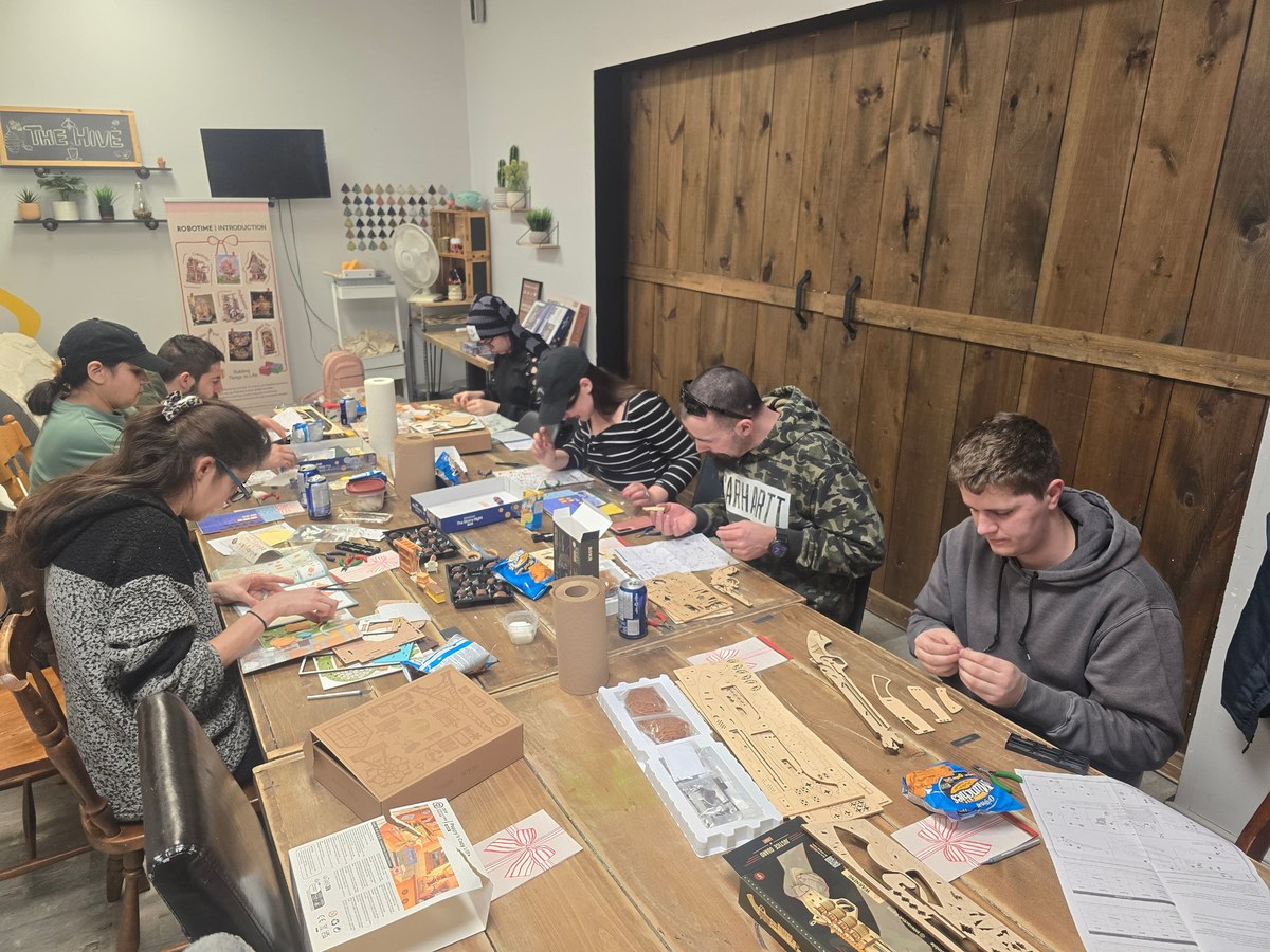 Makers building Robotime kits together around a table in Thunder Bay