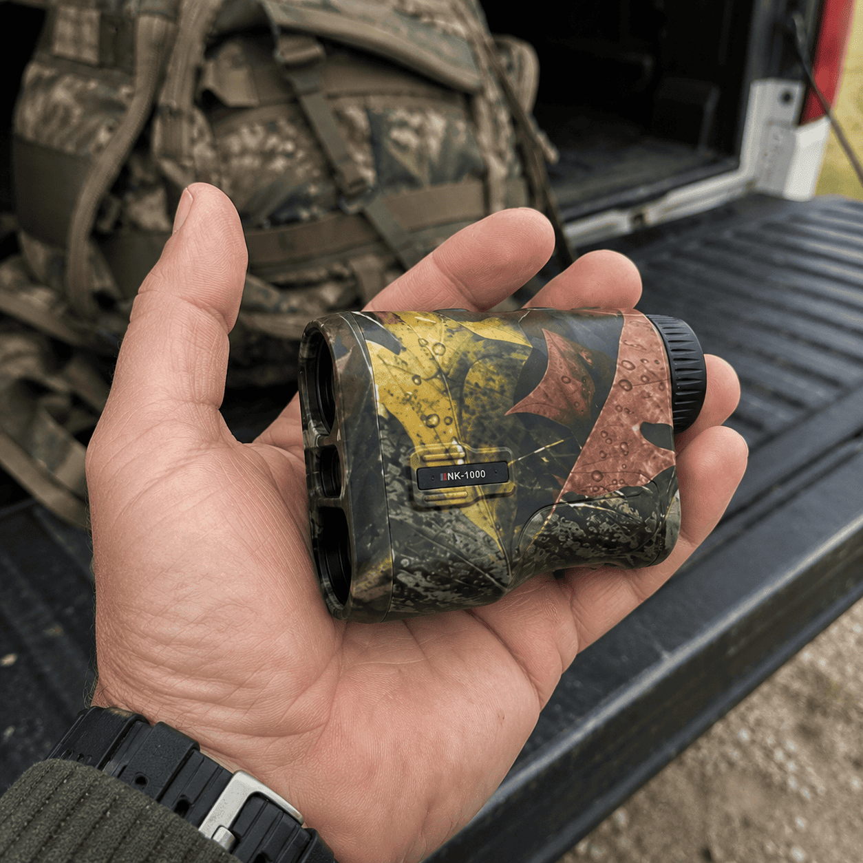 Compact rangefinder held in hand at the truck