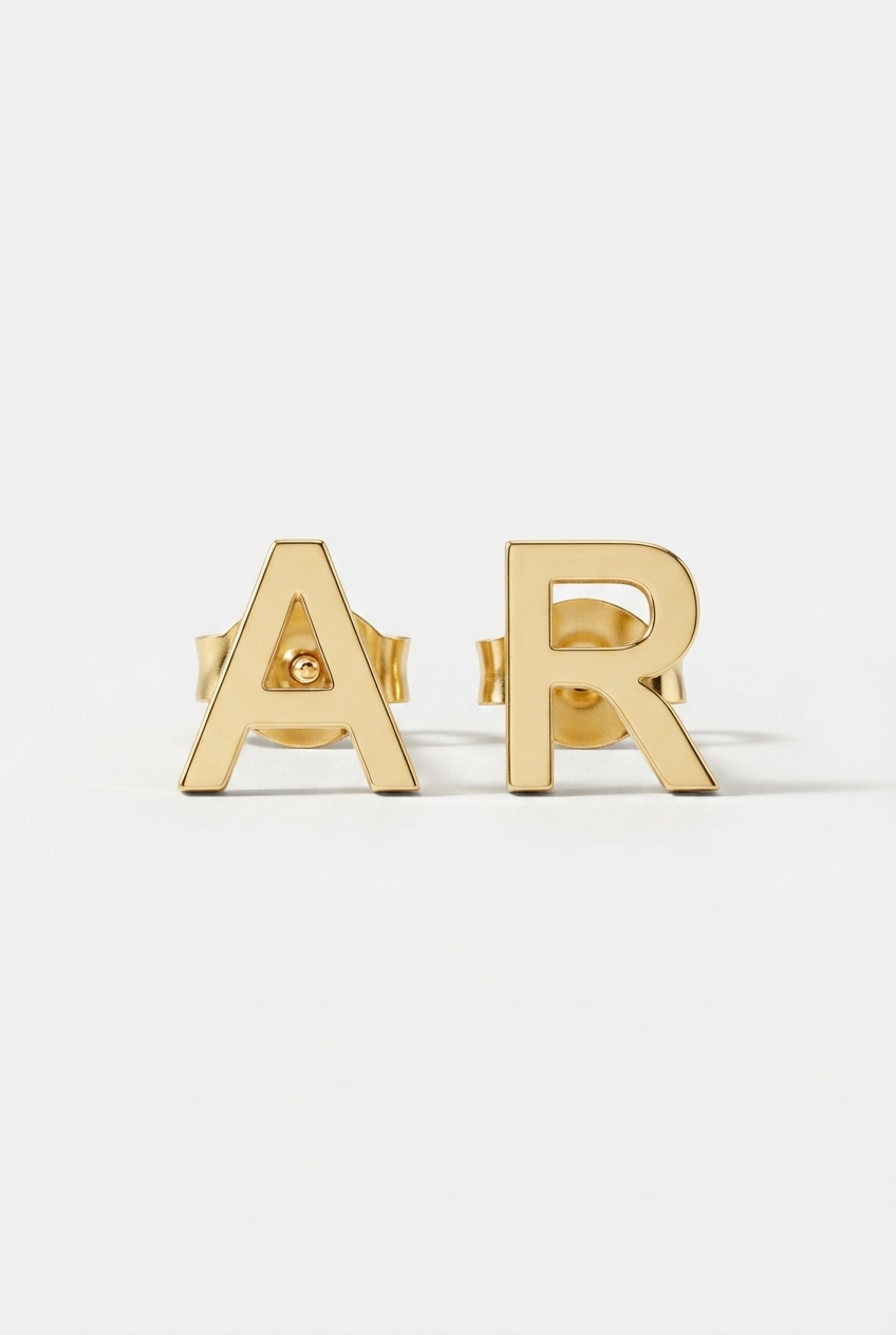 Initial stud earrings on off-white background