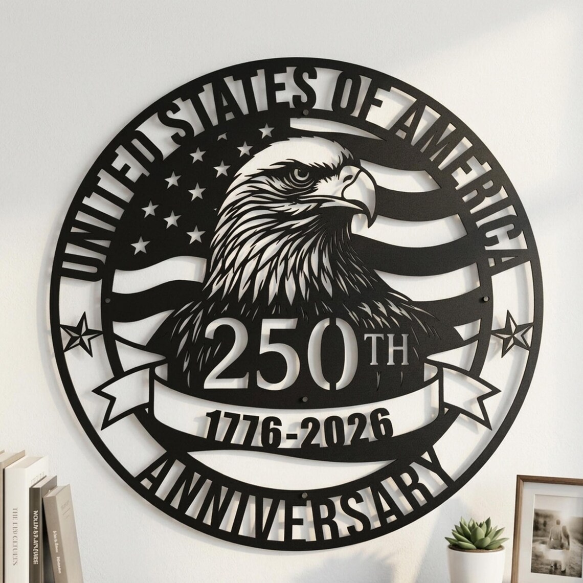 May include: Black metal wall art featuring an eagle and the text "UNITED STATES OF AMERICA" and "250TH ANNIVERSARY 1776-2026". The design includes the American flag and stars. A decorative piece for patriotic decor.