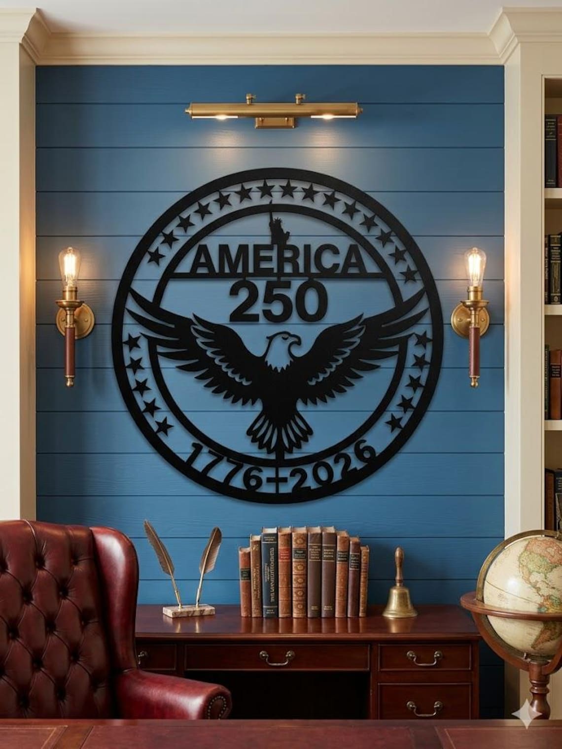 May include: A black metal wall art piece with the text "AMERICA 250" and an eagle design. The art piece is circular, with stars around the edge and the dates "1776-2026" at the bottom. It is mounted on a blue wall.