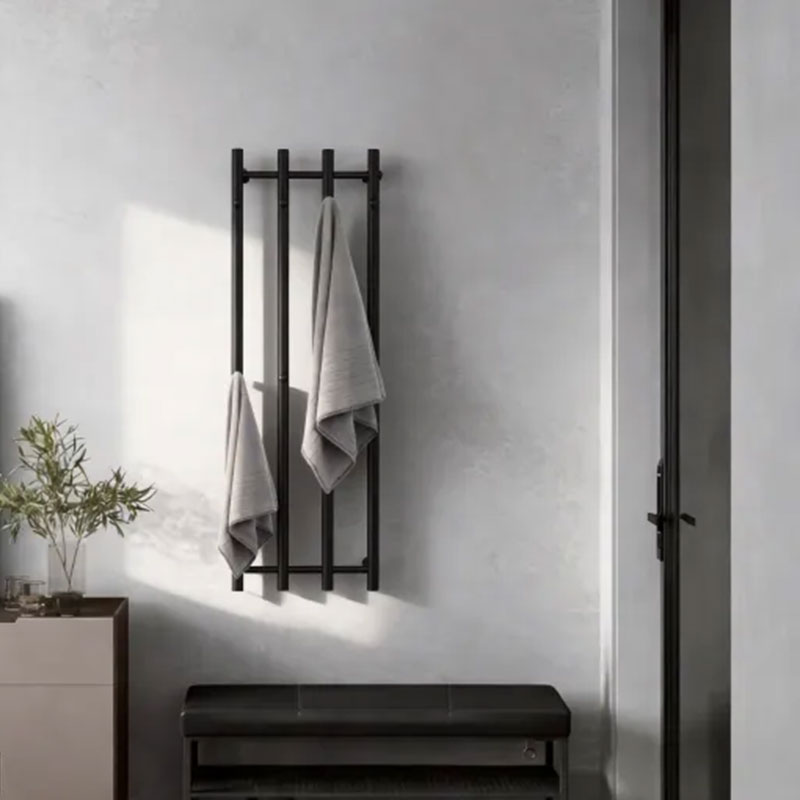 A sleek, matte black electric towel warmer installed on a dark marble wall.