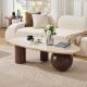 inexpensive modern coffee table with oval marble top and sculptural wood base styled in cozy living room with sofa and décor