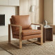 Affordable armchair styled in a cozy living room, featuring brown leather upholstery and solid wood arms for everyday comfort

