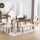 Dining room decorated for Christmas featuring four payson upholstered dining chairs and a matching bench around a wood table.

