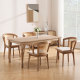 modern farmhouse upholstered dining chairs arranged around solid wood dining table in bright farmhouse dining room setting
