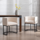 Industrial upholstered dining chairs in beige fabric with black metal base, styled beside a modern dining table