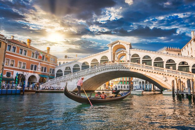 Photo traditional gondola near world famous canal grande and rialto bridge