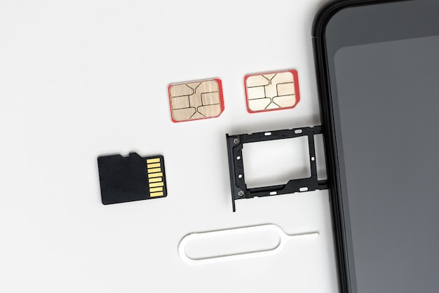 Photo sim cards, a memory card, a pin near the smartphone