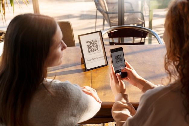 Free photo young women scanning qr code