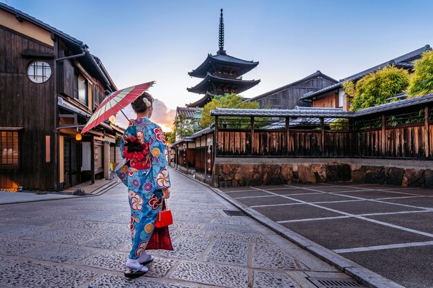 Free photo woman wearing japanese traditional kimono with umbrella at yasaka pagoda and sannen zaka street in kyoto, japan.