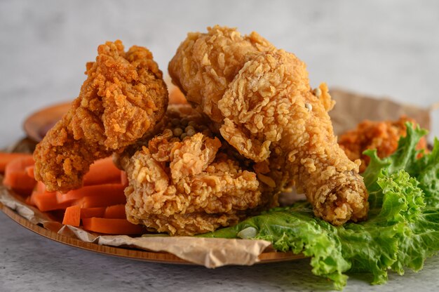 Free photo crispy fried chicken on a plate with salad and carrot