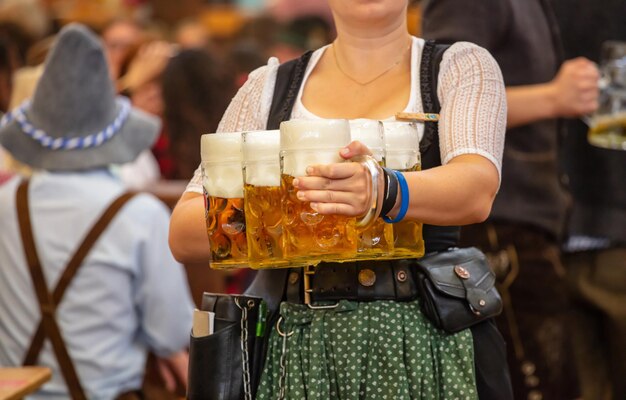 Photo oktoberfest munich germany waiter with traditional costume holding beers
