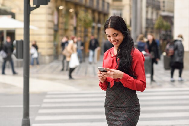 Photo gratuite d'une femme d'affaires brune riant avec son mobile