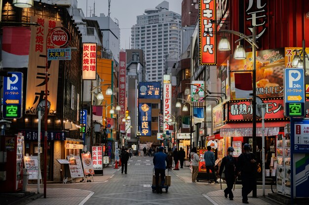 Photo gratuite de personnes marchant dans une rue au Japon la nuit.