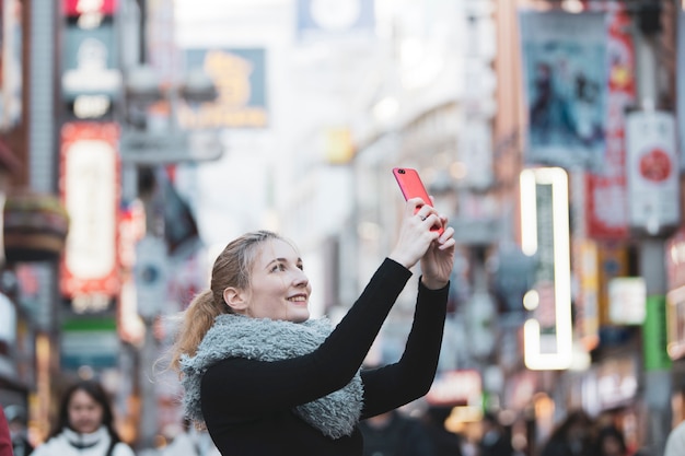 Photo d'une jeune femme prenant des photos de la ville de Tokyo