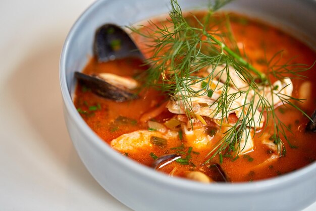Photo food, new nordic cuisine, culinary and cooking concept - close up of seafood soup with fish and blue mussels in bowl