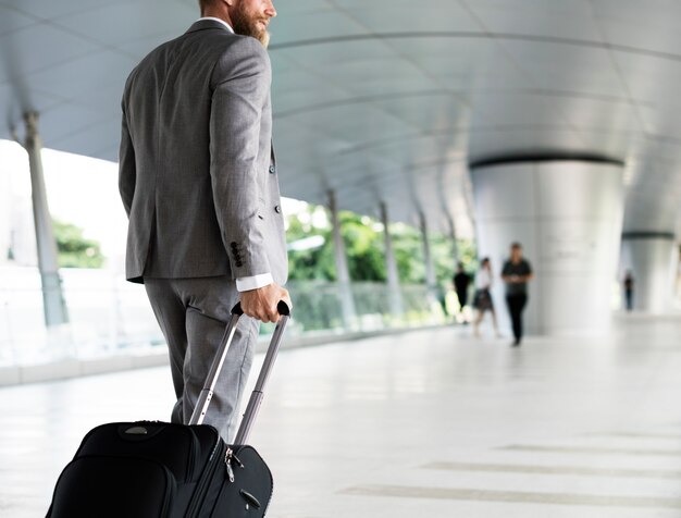 Free photo businessman holding luggage for business trip