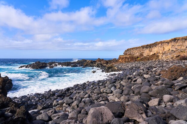 Photo water breaks on pebbles and rocks on an empty beach in the atlantic ocean sunset in the ocean