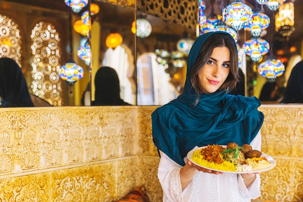 Free photo woman holding dish of arab food