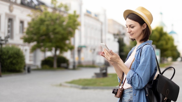Free photo traveller with hat browsing mobile phone