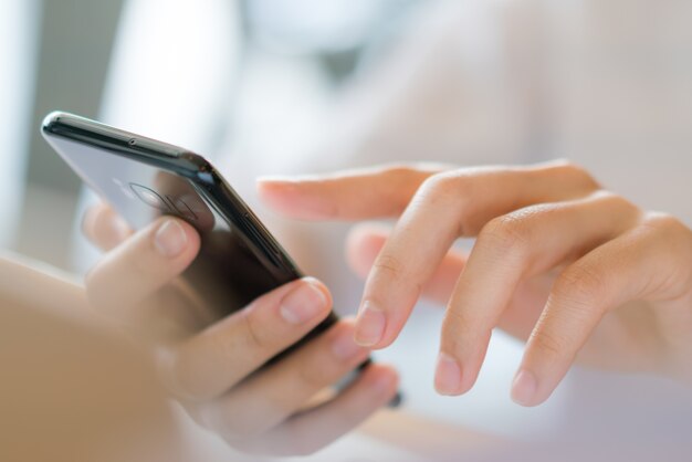 Foto gratuita de una mano de negocios con un teléfono móvil.