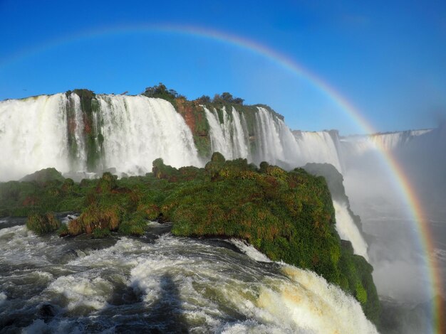 Free photo beautiful scenery of a rainbow over a waterfall in iguazu national park, cataratas, argentina