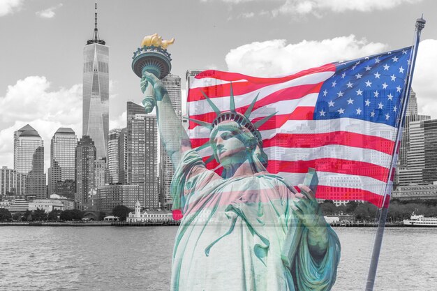 Photo statue of liberty with a large american flag and new york skyline in the