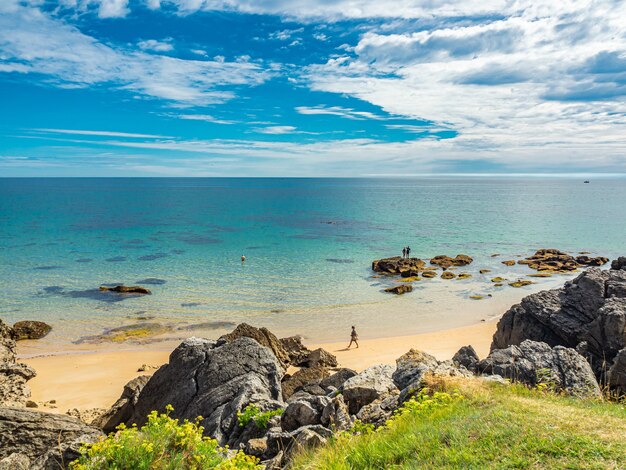 Free photo panoramic shot of a rocky white beach on thin clouds background