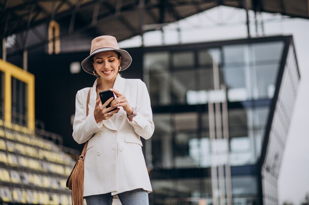 Free photo young attractive woman in white jacket walking outdoors
