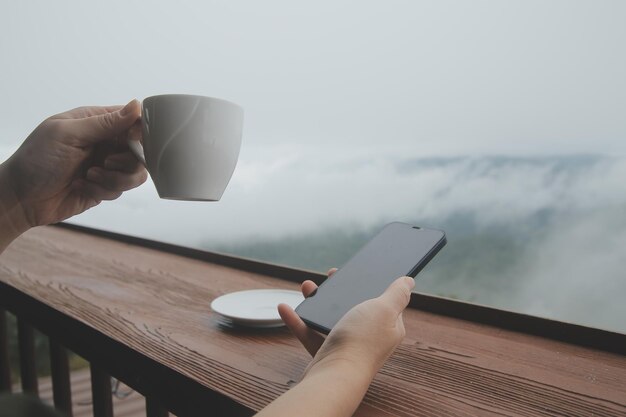 Photo young man freelancer traveler wearing hat anywhere working online using laptop and enjoying mountains view