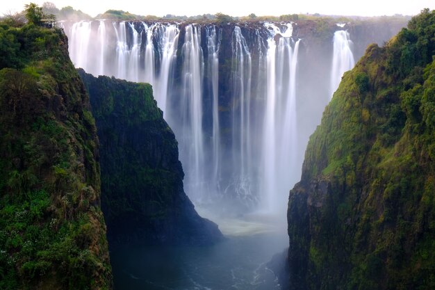 Free photo beautiful shot of a waterfall surrounded by trees and hills