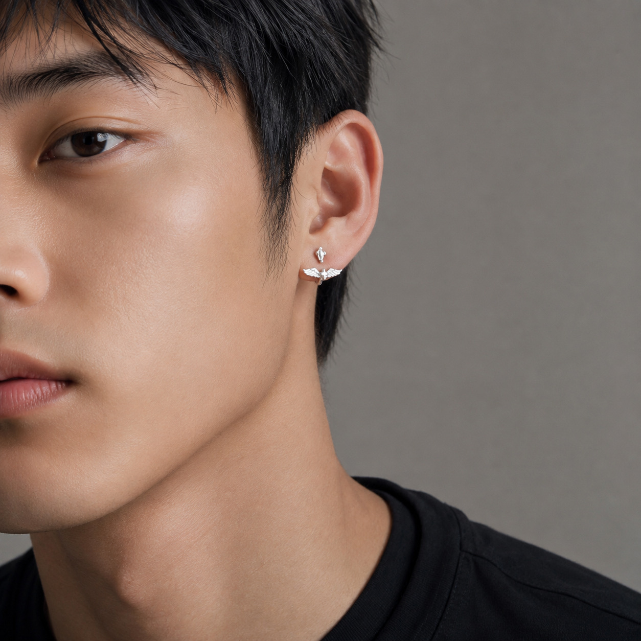 Man wearing Angel N°1 Ear Studs, sterling silver wing charm
