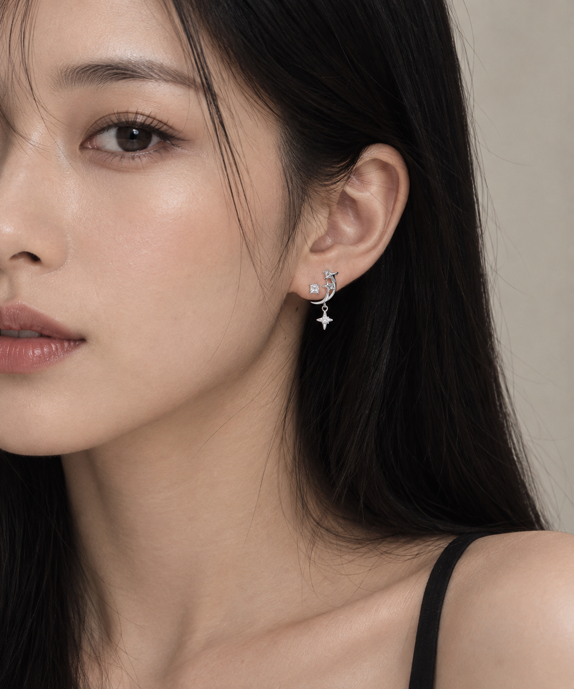 Side view of Starla N°3 earrings on a female model ear, white zircon drop catching light