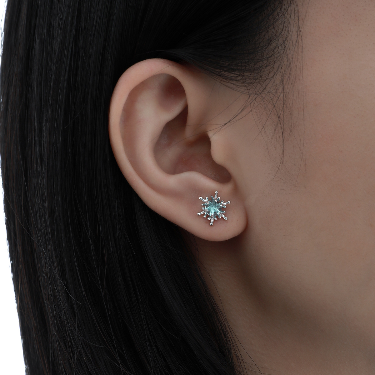 Blue crystal snowflake sterling silver earring worn on woman