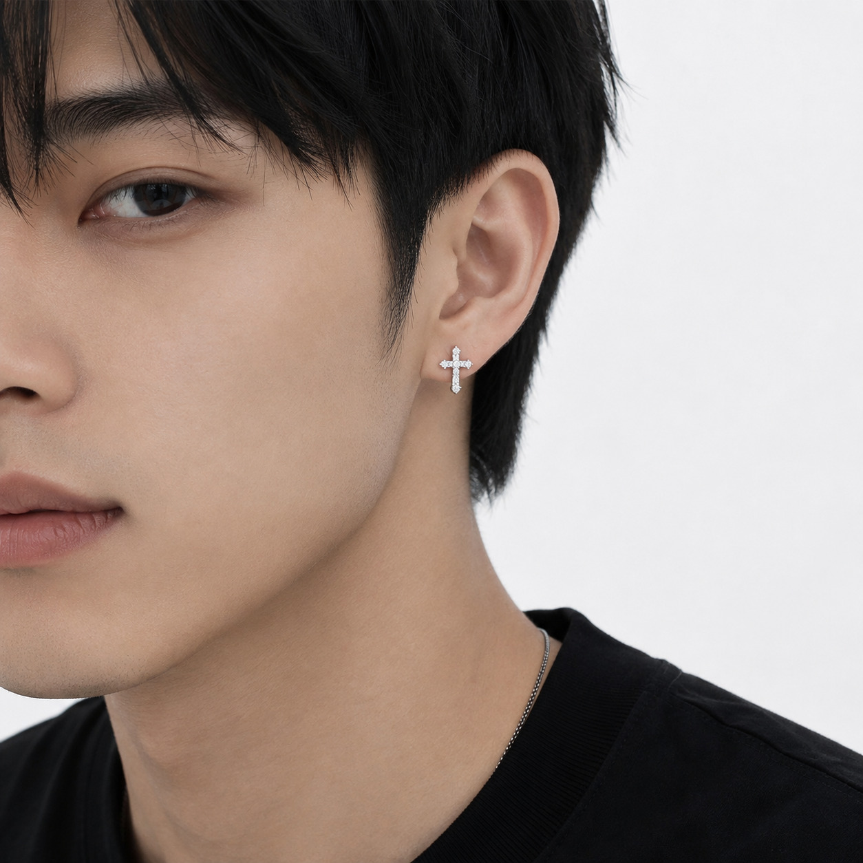 Man wearing Christina Ear Studs, silver cross detail