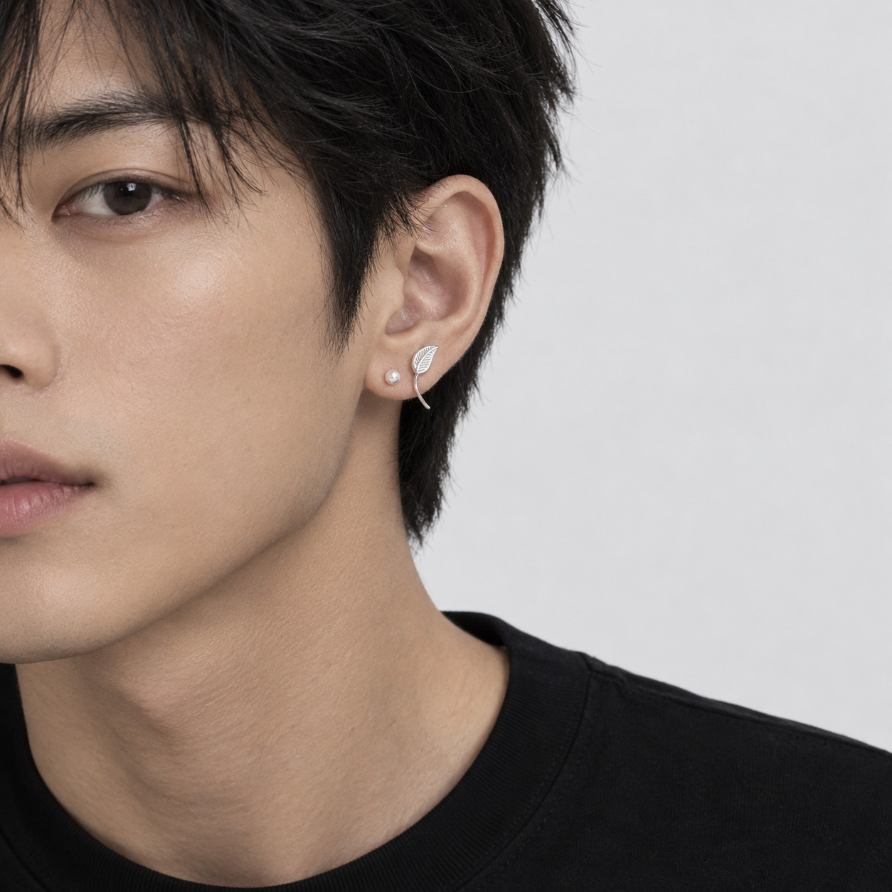 Leaf-inspired earrings worn by a male model