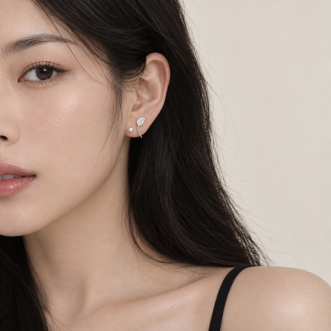 Leaf-inspired stud earrings worn by a female model