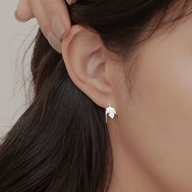 Maple leaf silver ear studs worn on ear